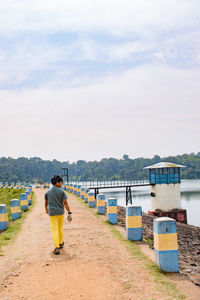 People at reservoir against sky