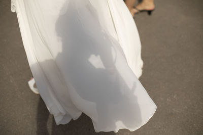Low section of woman standing on white umbrella