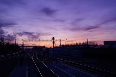 Train at railroad station against sky during sunset