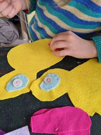 Midsection of girl making sewing item
