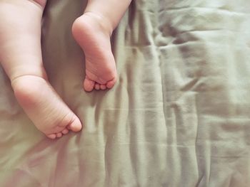 Low section of baby on bed