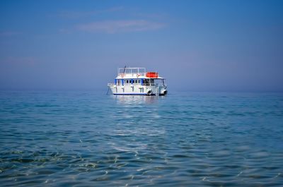 Boat sailing in sea against blue sky