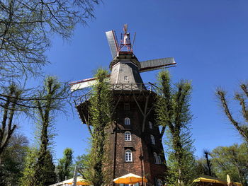 Low angle view of traditional windmill against blue sky
