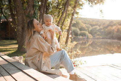 Smiling young mother playing with baby boy 1 year old wear casual clothes over nature background