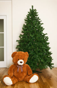 Christmas tree and teddy bear on floor at home