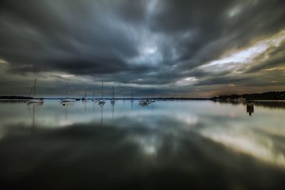 Scenic view of sea against cloudy sky at sunset