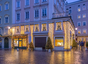 Illuminated building by street at night