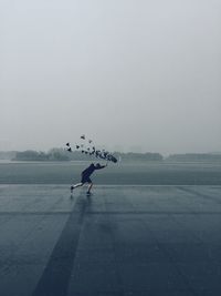 Woman with umbrella against clear sky