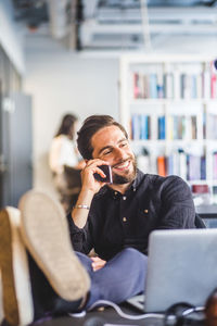 Man using mobile phone while sitting on table