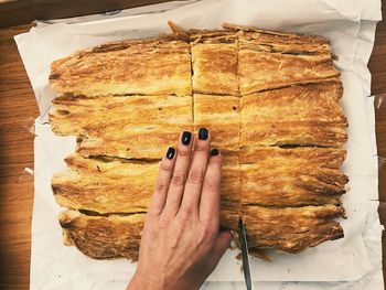 Directly above shot of hand cutting pastry