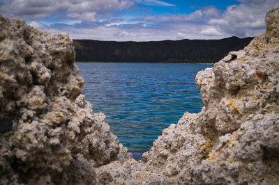 Rock formation on sea shore against sky