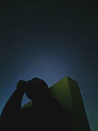 Low angle view of silhouette man against sky at night