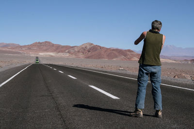 Man standing on road against desert