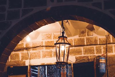 Low angle view of illuminated pendant lights hanging from ceiling