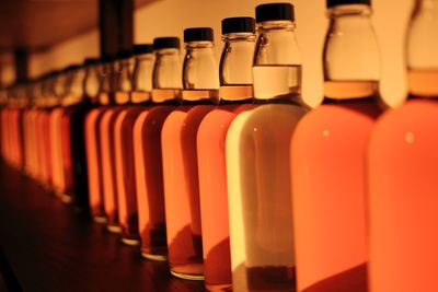 Orange whisky bottles in row on table