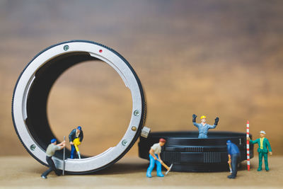 Close-up of figurines repairing wristwatch on table