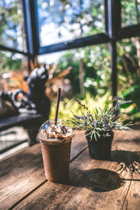 Glass of potted plant on table