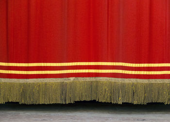 Close-up of red curtain hanging on stage