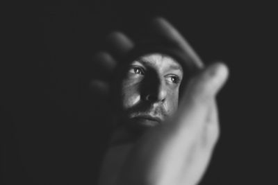 Portrait of man against black background