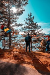 Rear view of man standing on field against sky