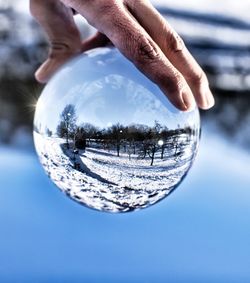 Digital composite image of hand holding crystal ball