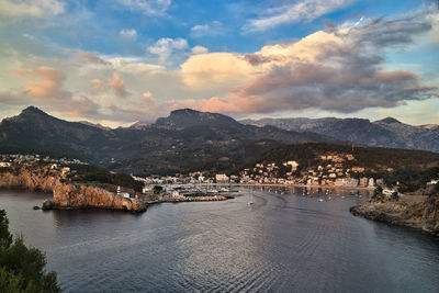 Townscape by sea against sky during sunset