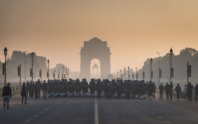 Rear view of army soldiers at india gate during sunrise