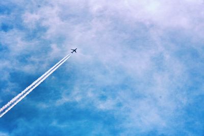 Low angle view of vapor trail against blue sky