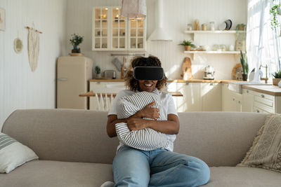 Young woman sitting on sofa at home