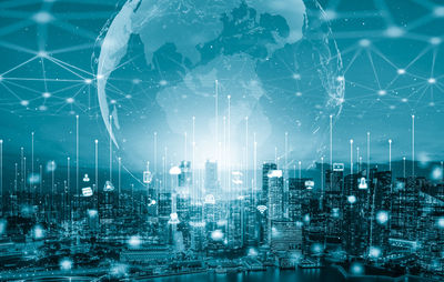 Digital composite image of illuminated cityscape against sky at night