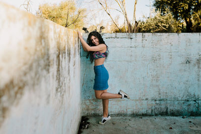 Portrait of beautiful woman standing at abandoned swimming pool