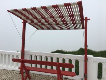 Empty seats by railing against clear sky