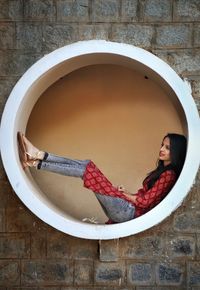 Portrait of young woman against wall