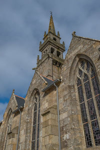 Low angle view of bell tower against cloudy sky