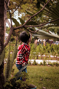 Boy standing by tree