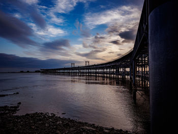 View of bridge over sea against cloudy sky