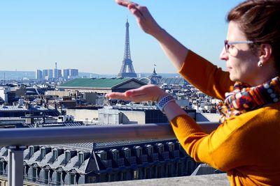 Portrait of boy holding camera against sky