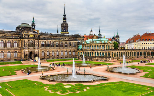 Fountain in city against sky