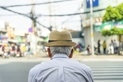 Rear view of man wearing hat on street