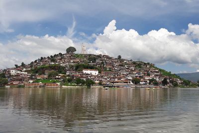 Townscape by lake against sky in town