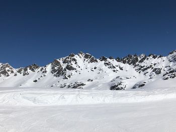 Scenic view of snowcapped mountains against clear blue sky