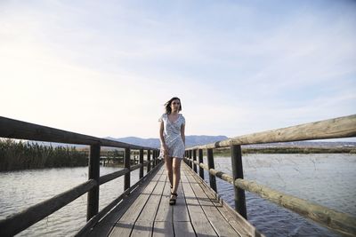 Man standing on pier against sky