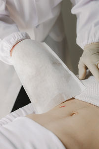 Midsection of doctor examining patient in hospital