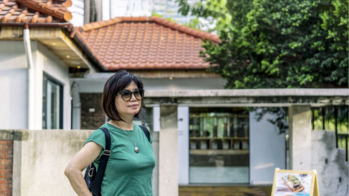 Woman standing before a house