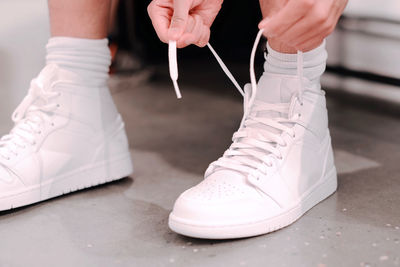 Low section of man tying shoelace