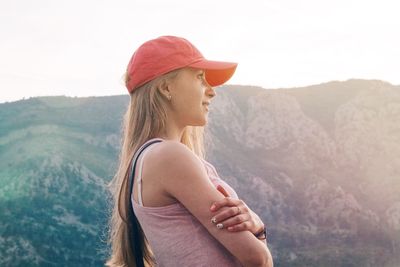 Young woman standing against mountain