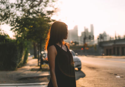 Rear view of woman standing in city against sky