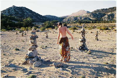 Rear view of woman standing on landscape against sky