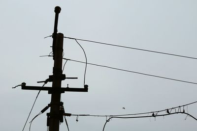 Low angle view of power lines against clear sky