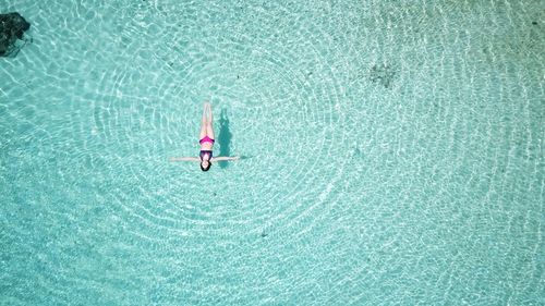 High angle view of woman floating on sea